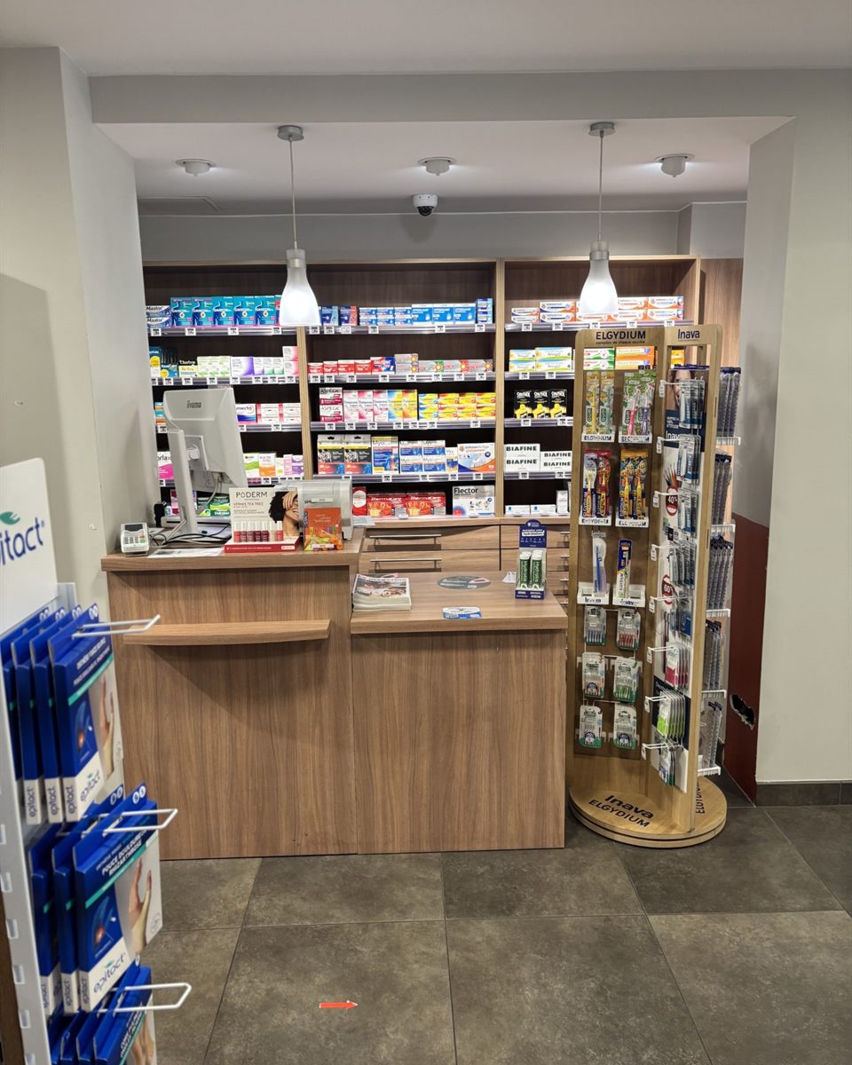 Comptoir de conseil de la Pharmacie du Pont Neuf, devant les rayonnages de médicaments