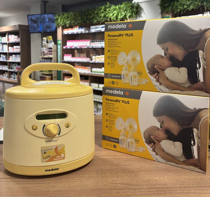 Tire-lait électrique Medela Symphony à usage hospitalier posé sur le comptoir de la Pharmacie du Pont Neuf à Annecy, à côté de deux sets d'accessoires PersonalFit PLUS pour double pompage