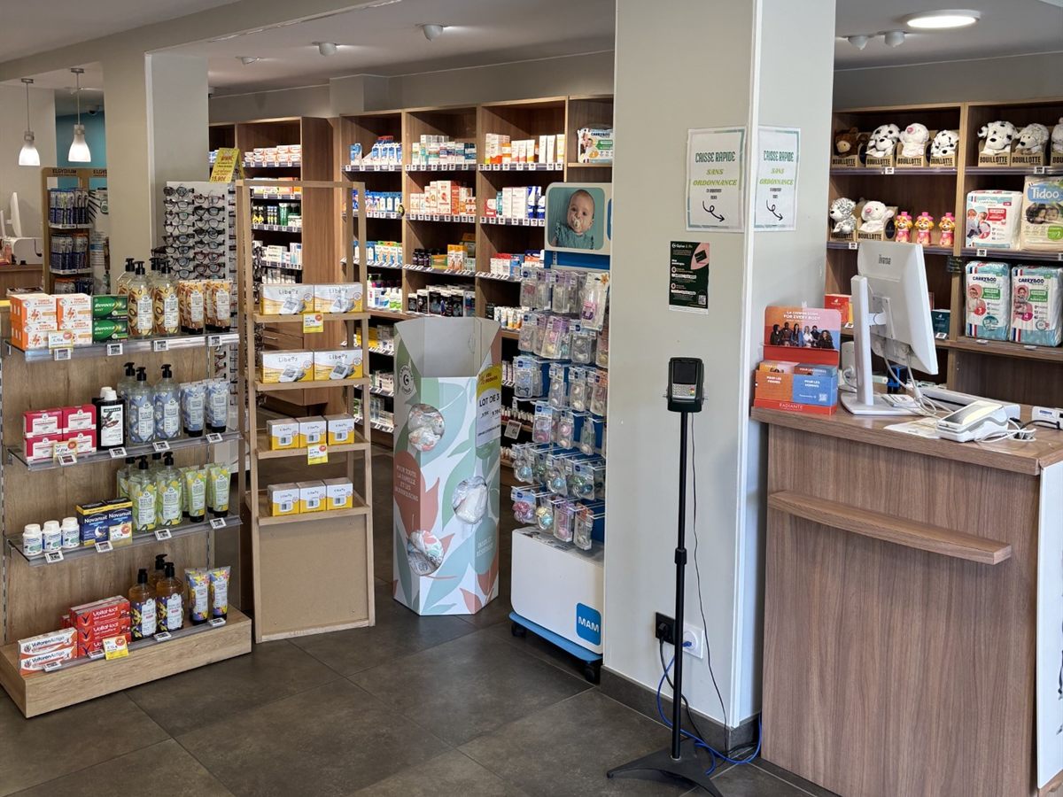 Entrée de l'officine : gondoles, présentoir puériculture et premier comptoir